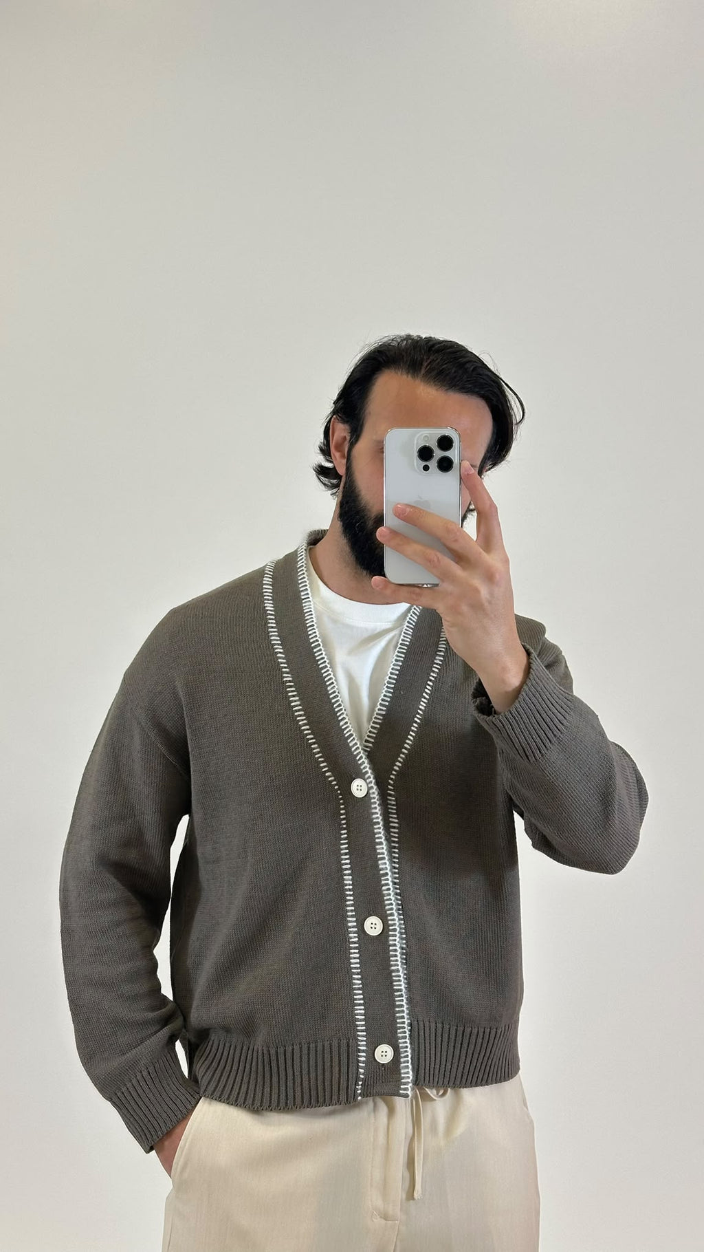 Cardigan in maglia grigio con profili bianchi a contrasto, dettaglio da vicino