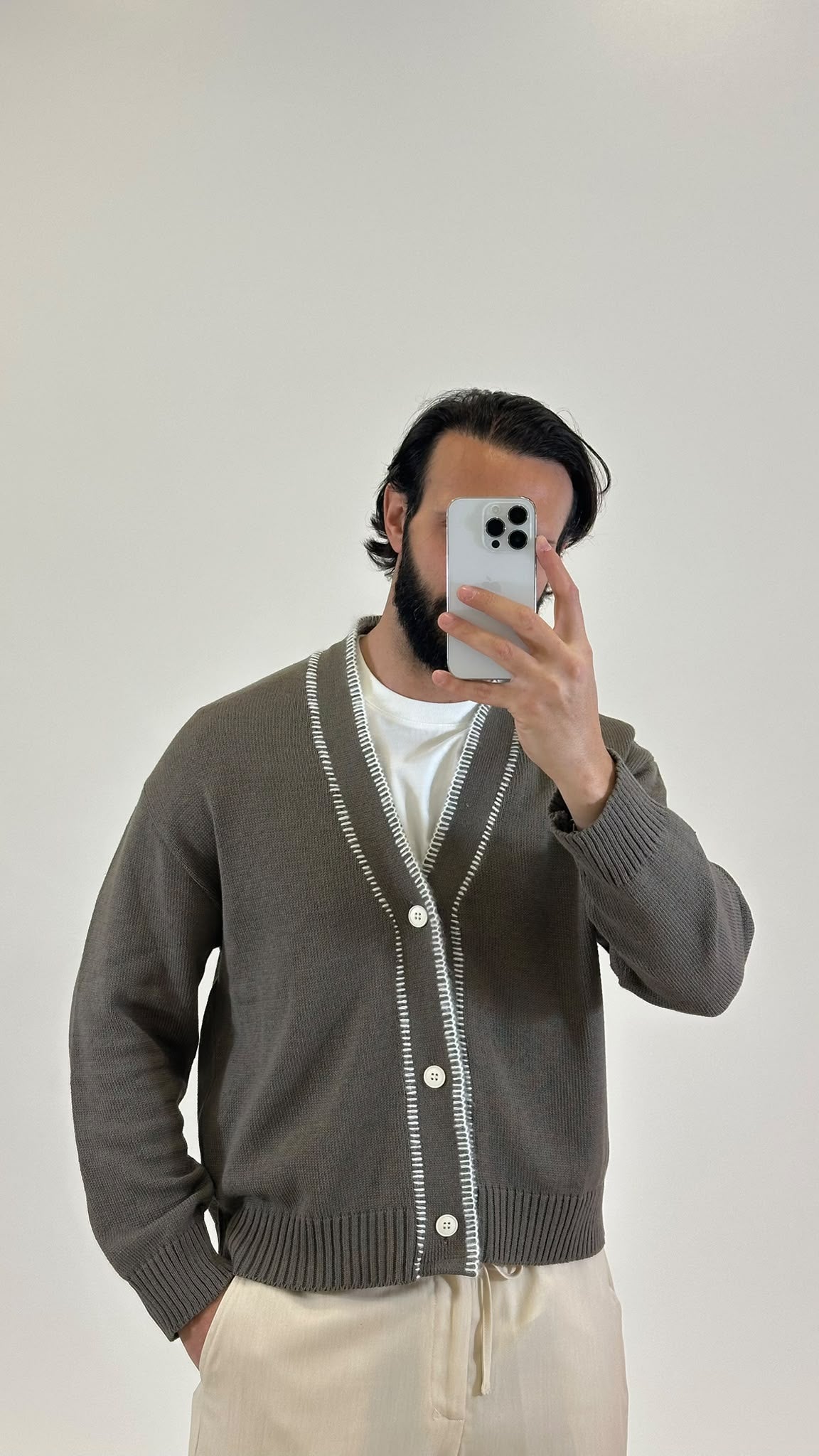 Cardigan in maglia grigio con profili bianchi a contrasto, dettaglio da vicino